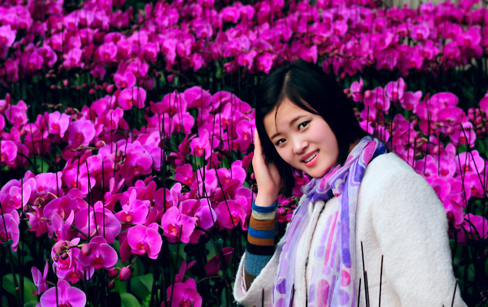 美丽蝴蝶兰中的少女